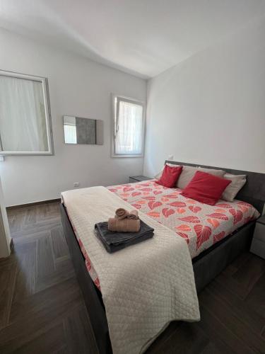 une chambre avec un grand lit avec des oreillers rouges dans l'établissement Residence Riccardo, à Chioggia