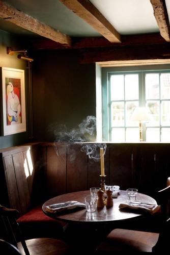 a table in a restaurant with a window at The Queen's Head in Broad Chalke