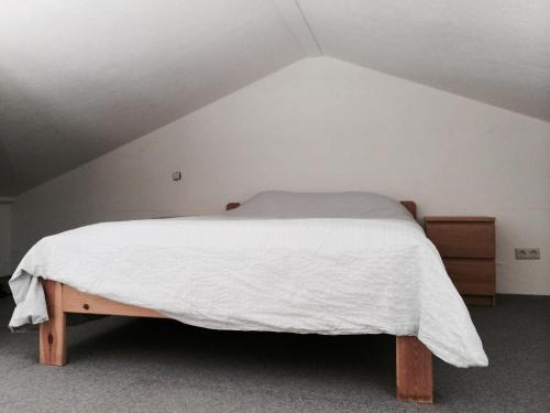 een slaapkamer met een bed met een wit dekbed bij Almost At The Beach in Wijk aan Zee