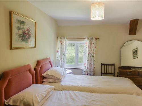 sypialnia z 2 łóżkami i oknem w obiekcie Riverbank w mieście Axminster