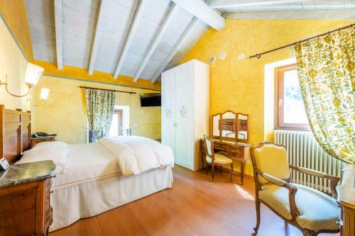 a bedroom with a white bed and a desk and a window at La Griglia in Argegno