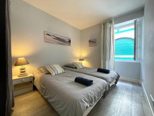 une chambre avec un lit avec deux oreillers dessus dans l'établissement Maison spacieuse terrasse ensoleillée proche Océan, à Biarritz