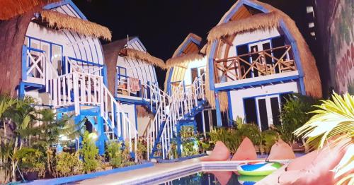 ein Hotel mit blauen und weißen Gebäuden und einem Pool in der Unterkunft Tropical House Bungalows in Gili Trawangan