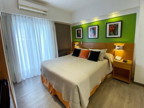 a bedroom with a large bed and a green wall at Sarmiento Palace Hotel in Buenos Aires