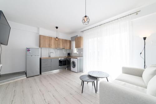 ein weißes Wohnzimmer mit einem Sofa und einem Tisch in der Unterkunft Dionysos Residential Complex in Ofrynio