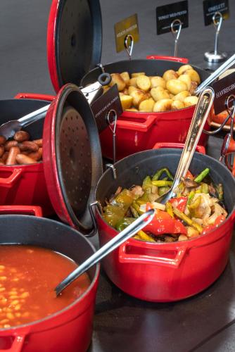 a bunch of pots filled with food on a table at Thon Hotel Ålesund in Ålesund