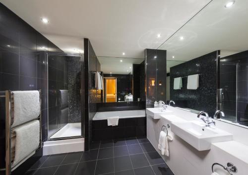 a bathroom with two sinks and a shower at The Townhouse Manchester in Manchester