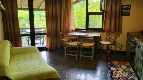 a kitchen with a table and chairs and a window at Guest House Fanny in Sinemorets