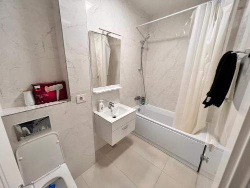 ein weißes Bad mit einem Waschbecken und einer Dusche in der Unterkunft 2 rooms apartment Airy & Bright Palas Joy in Iaşi