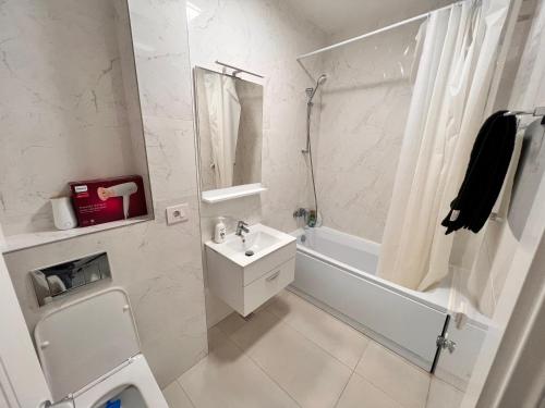 a white bathroom with a sink and a shower at Central Metropolitan Bright 1 in Iaşi