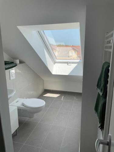 a bathroom with a toilet and a skylight at Wohnung im Gästehaus in Bernau bei Berlin
