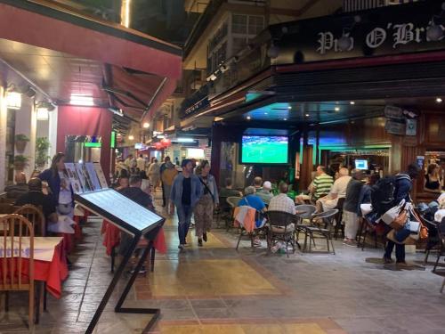 a group of people walking around a crowd of people in a restaurant at Best location in Fuengirola! in Fuengirola