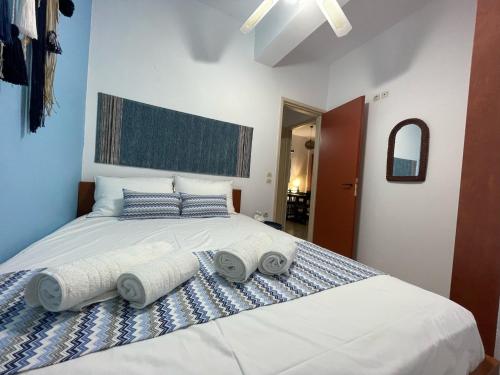 a bedroom with a large bed with towels on it at Mediterranean Dolphin Guest House in Paránimfoi