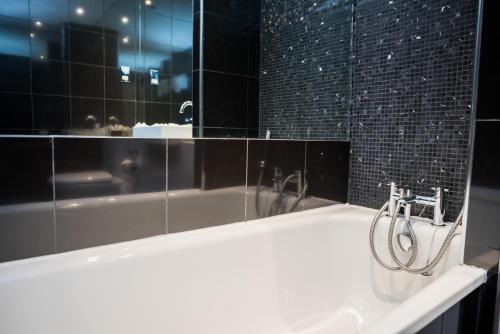 a bathroom with a sink and a bath tub at The Townhouse Manchester in Manchester