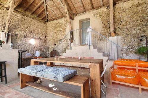 Zimmer mit einem Holztisch und einer Treppe in der Unterkunft Maison avec grange & piscine vue sur les Pyrénées in Puymaurin