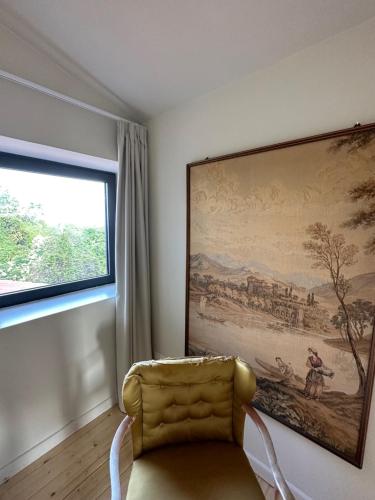 a yellow chair in a room with a painting on the wall at La casa di Zoe-ARTANDTRAVEL in Montefiascone