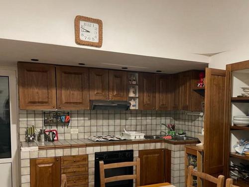 uma cozinha com armários de madeira e um relógio na parede em I Trulletti di nonna MIMMA em La Correggia