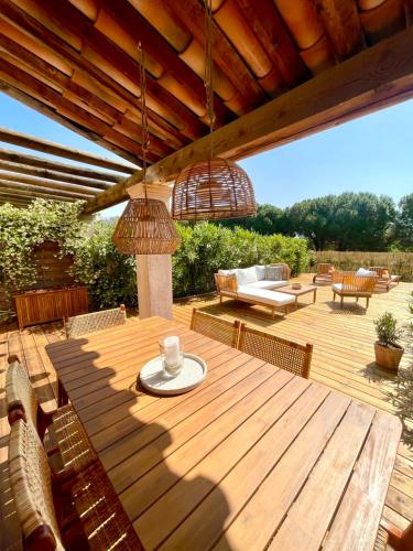 una terraza de madera con mesa y sillas de madera en Window On Ramatuelle, en Saint-Tropez