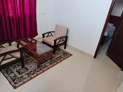 een woonkamer met 2 stoelen en een salontafel bij Pal Homestay Shimla in Shimla