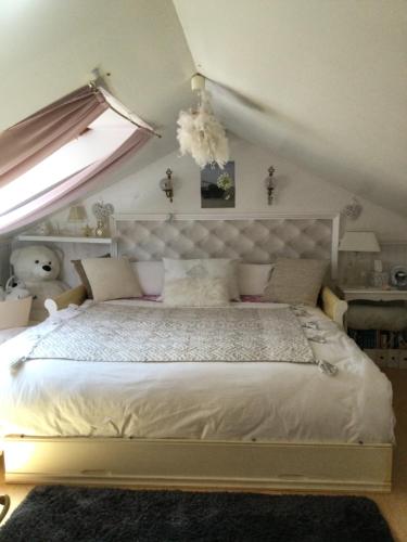 Le Havre de paix في سان سير سور لوار: غرفة نوم مع سرير أبيض كبير مع نافذة