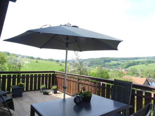 a table with an umbrella on a balcony at Ferienwohnung Traumblick in Beerfelden