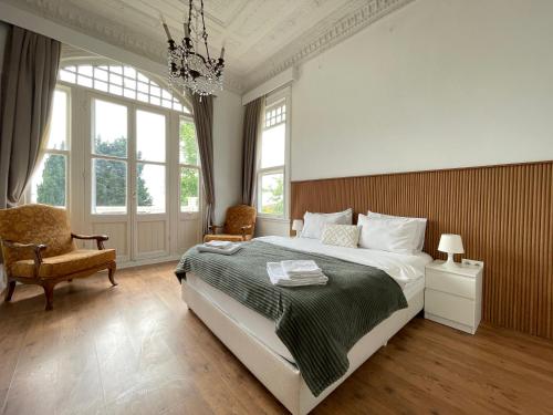 a bedroom with a large bed and a chandelier at Ikigai Hotel Villa Rıfat in Adalar