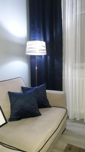 a lamp sitting next to a couch with pillows at VIEW APARTMENT in Visoko