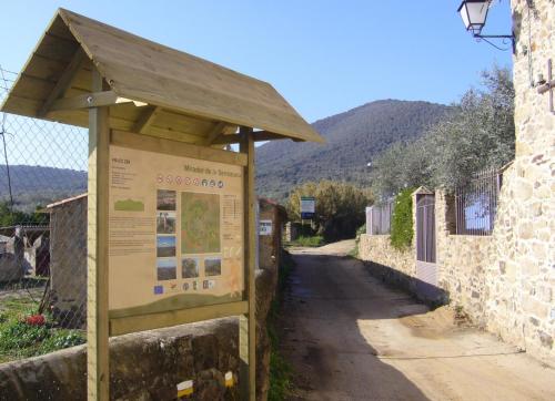 a sign in front of a building next to a road at CASA RURAL La Moranta in Herguijuela