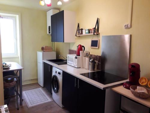 a kitchen with a refrigerator and a washer and dryer at "Soleil" - appart étage 2 - Loc'h finistère - N6 in Quimper