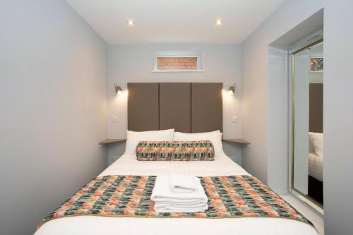 a small bedroom with a bed with towels on it at Townhouse No.1 in Aberystwyth