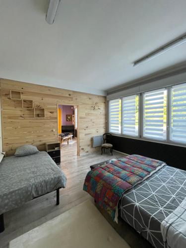 um quarto com uma cama, uma secretária e janelas em Chez Léandre em Vitry-le-François