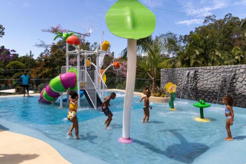 a group of children playing in a swimming pool at Hotel Fazenda Vilarejo All Inclusive in Conservatória