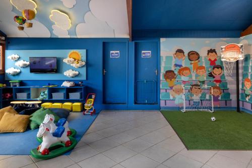 a childs room with a blue wall with a mural at Hotel Fazenda Vilarejo All Inclusive in Conservatória