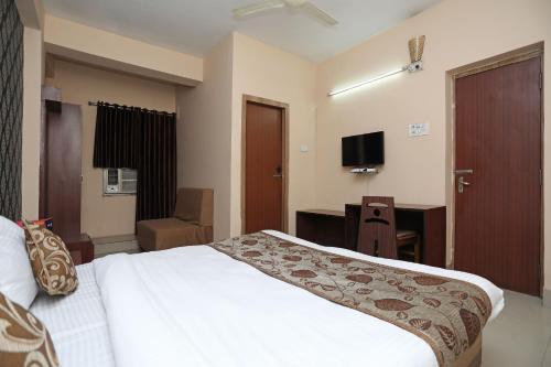 a bedroom with a bed and a desk and a television at Collection O Greenpark in Jamshedpur