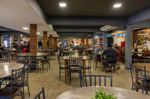 a restaurant with tables and chairs and people sitting at tables at Hotel Fazenda Vilarejo All Inclusive in Conservatória