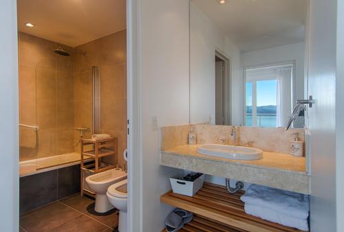 Un baño con lavabo e inodoro en Bariloche costa del lago Ollagua, vista al lago panoramica, piscina, cochera, en San Carlos de Bariloche