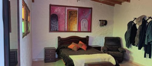 a bedroom with a bed and a chair in it at Finca La Carmela in El Peñol