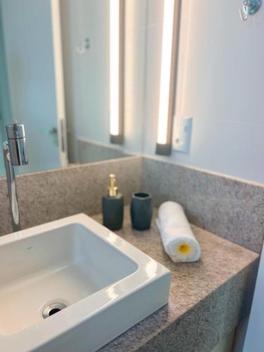a bathroom counter with a sink and a mirror at PALMAS EXPERIENCE - APARTAMENTO VISTA LAGO, próximo ao shopping in Palmas