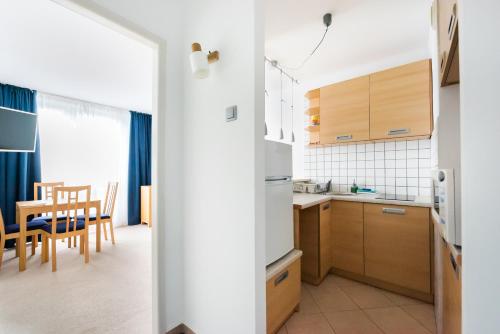 a kitchen and dining room with a table and chairs at Metro Rondo ONZ Yellow Apartment in Warsaw
