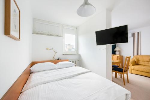 a white bedroom with a bed and a chair at Metro Rondo ONZ Yellow Apartment in Warsaw