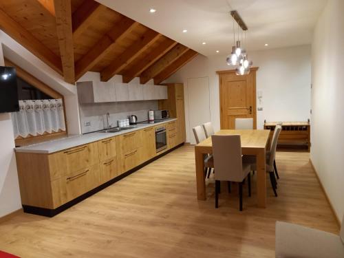a kitchen and dining room with a table and chairs at Appartamento Mansarda Patrizia e Franco Val di Sole in Commezzadura