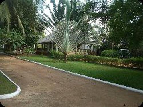 a house with a dirt road in front of a yard at Ayifa Center Hotel kansounkpa in Abomey-Calavi