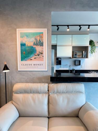 a living room with a couch in front of a kitchen at PALMAS EXPERIENCE - APARTAMENTO VISTA LAGO, próximo ao shopping in Palmas