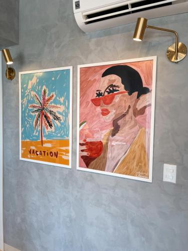 two posters of a woman on a wall at PALMAS EXPERIENCE - APARTAMENTO VISTA LAGO, próximo ao shopping in Palmas