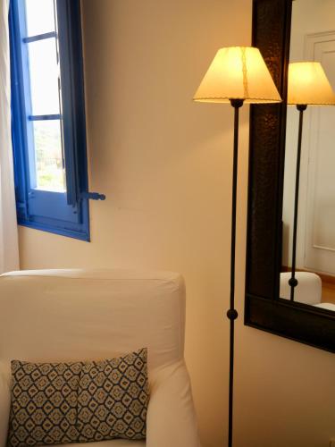 a living room with a couch and a lamp and a mirror at Hostal de la Plaça - Hotel Boutique in Cabrils