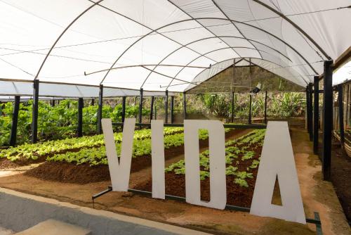 a greenhouse with a sign that reads vine at Hotel Fazenda Vilarejo All Inclusive in Conservatória