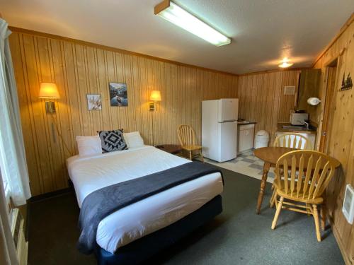 a bedroom with a bed and a table and a refrigerator at Columbia Point Resort in Kettle Falls