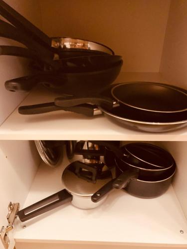 a shelf with a frying pan and pans on it at FELIX LIVING 6, modern & cozy 3 Zimmer Wohnung, Balkon, Parkplatz in Salzweg