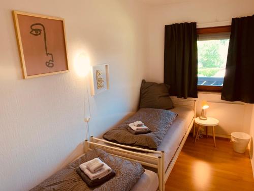 Habitación con 2 camas y ventana en FELIX LIVING 6, modern & cozy 3 Zimmer Wohnung, Balkon, Parkplatz en Salzweg