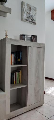 a wooden book shelf with books on it at La casa Ciarlasca in Lacchiarella